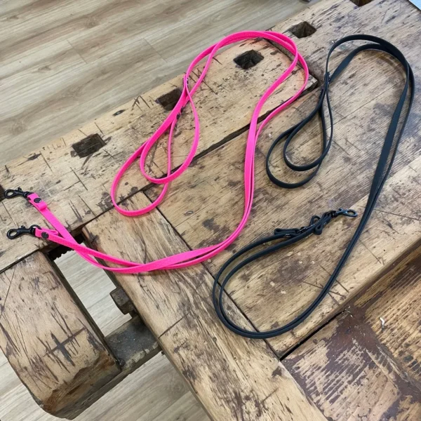 Mehrere Hundeleinen aus dem Material Hexa. Sie sind 1 cm breit und pink und schwarz. Die Hundeleinen haben schwarze Karabiner und Schrauben. Außerdem haben sie am Ende eine Hand Schlaufe.