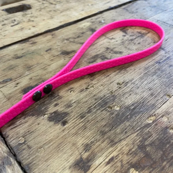 Eine Hundeleine aus dem Material Hexa sie ist 1 cm breit und pink. Hier ist der Ausschnitt der Hand Schlaufe gezeigt. Die Schrauben sind schwarz.