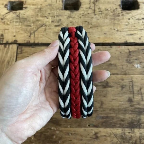 Halsband für Hunde aus dem Material Paracord. Das Halsband hat ein Biothane Adapter. Das Halsband besteht aus den Farben, schwarz rot und weiß.
